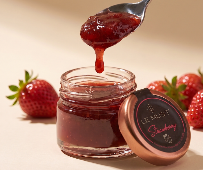 Le Must Premium strawberry jam jar with a spoon