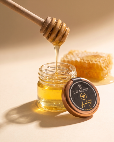 Le Must Premium Natural Wildflower Honey, 28 grams, open jar with a honey dipper
